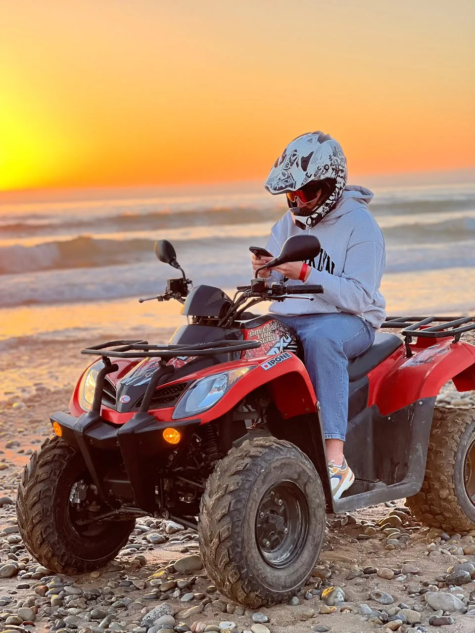 Quad bike rider by the Atlantic coast at sunset